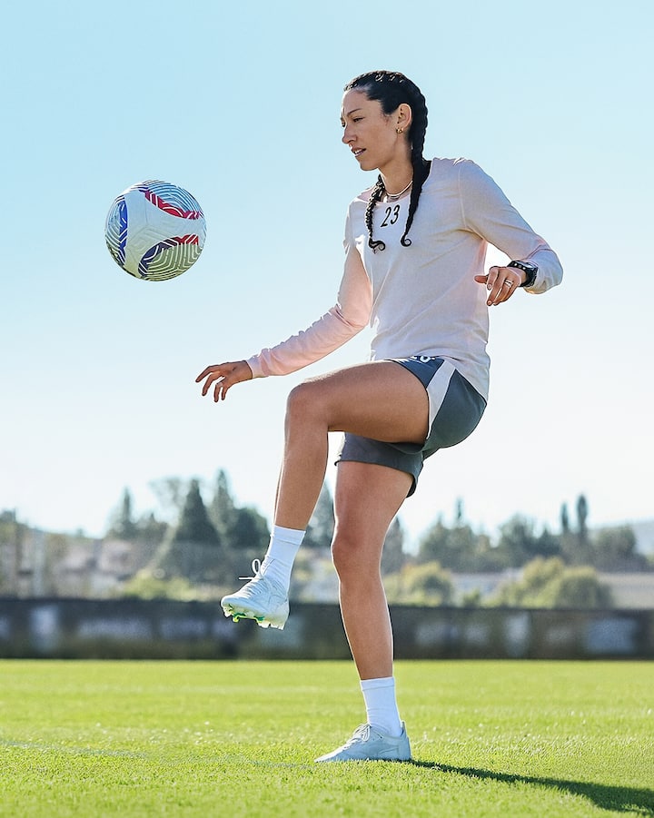 Christen Press jongle avec un ballon de soccer sur un terrain extérieur.