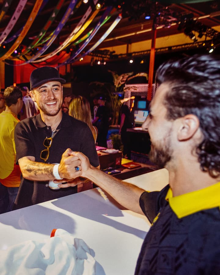 Deux hommes échangent une poignée de main secrète au-dessus d'une table dans un club.
