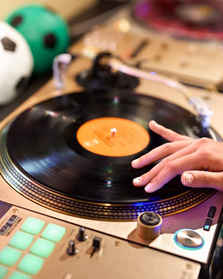 Un gros plan sur une main qui fait tourner un disque.