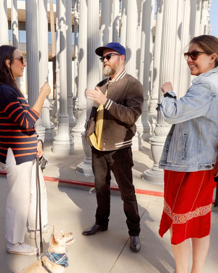 Trois personnes discutent devant l'installation Urban Lights à Los Angeles.