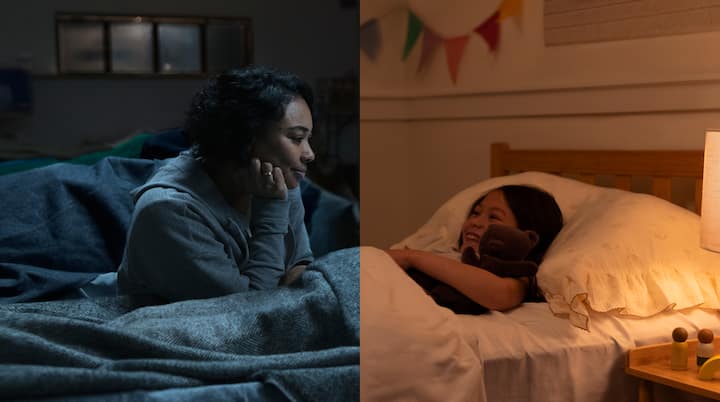 A photo shows a mother on a storm shelter cot looking into a second side-by-side scene of a smiling child in bed in a warm bedroom.