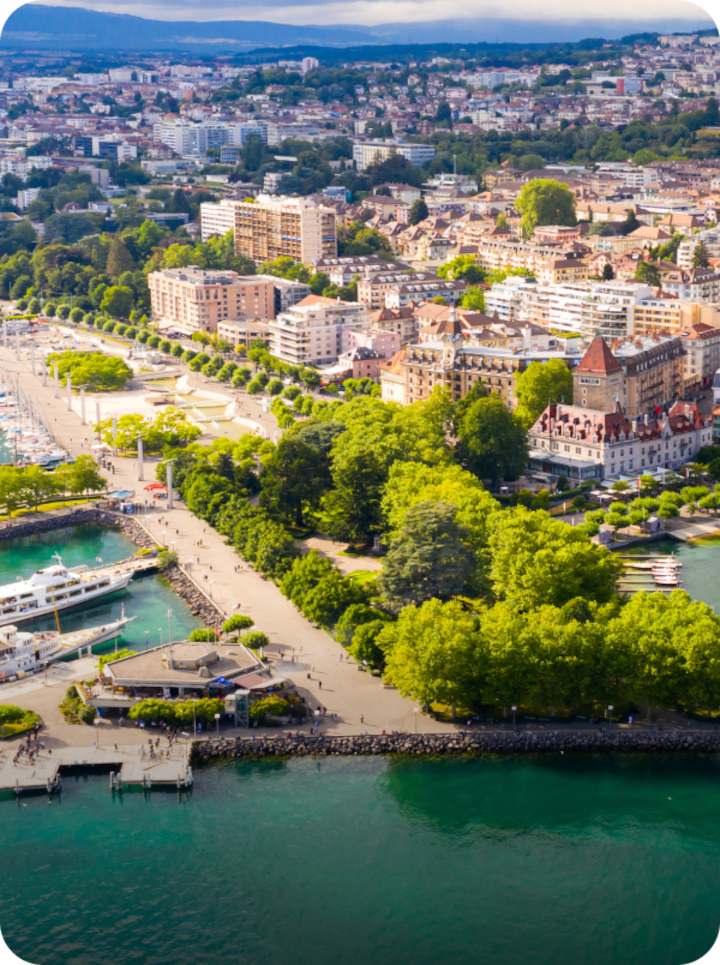 Vue aérienne du paysage urbain en bord de lac à Lausanne. Texte superposé : « Étape 1 Lausanne », avec une flèche vers la droite.