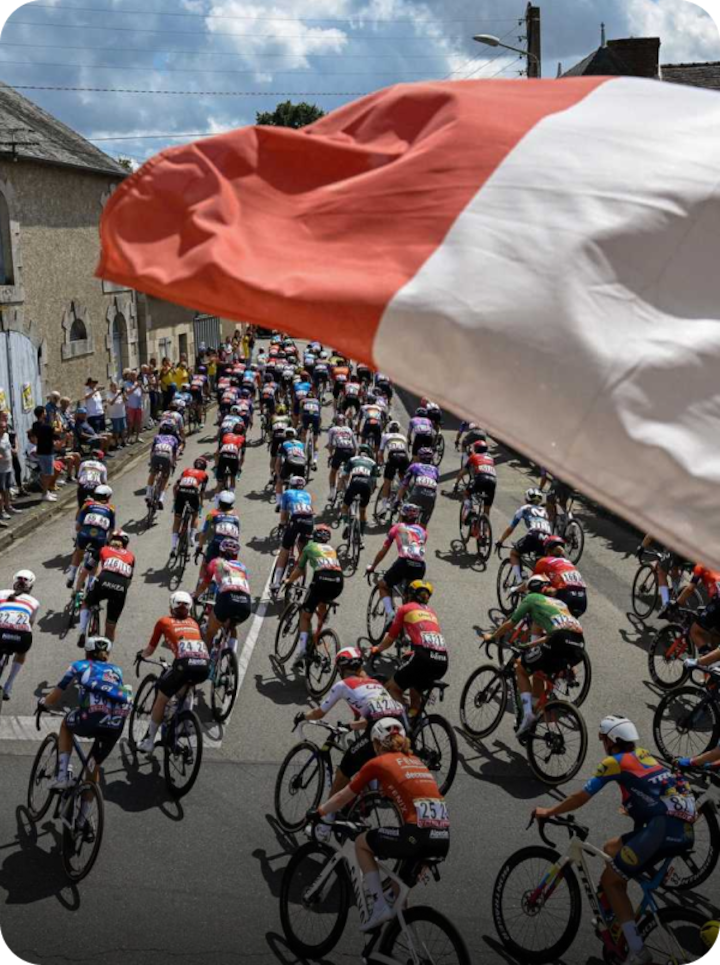 Des cyclistes professionnels traversent Mâcon sous les acclamations de la foule, avec un drapeau français au premier plan. Texte superposé : « Étape 5 Mâcon », avec une flèche vers la droite.