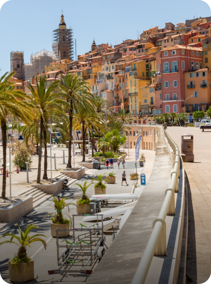 Une vaste promenade au bord de la mer à Nice, avec la mention « Étape 9 Nice » en bas à gauche et une flèche vers la droite.