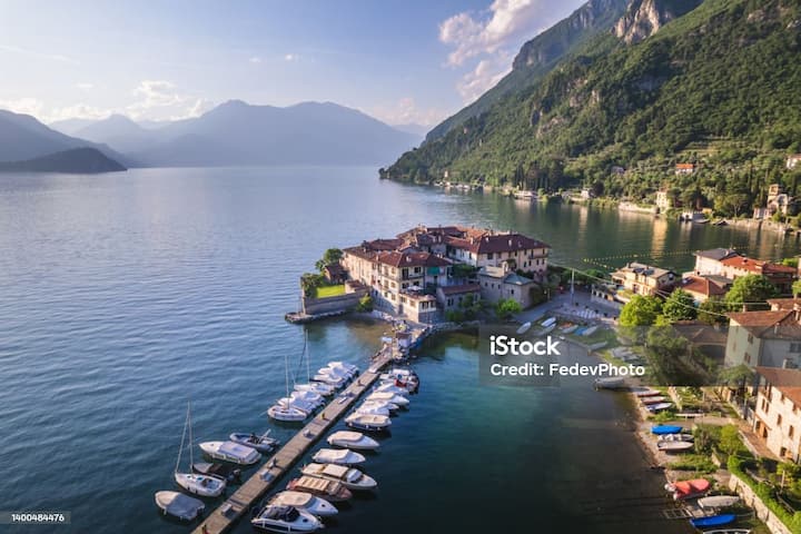 Pittoresco borgo sul lago in Italia rurale con piccola marina, esempio di comune che puoi scoprire tramite Airbnb.