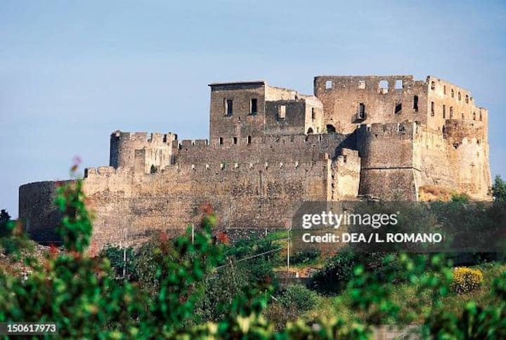 Antico castello rurale italiano circondato dal verde, simbolo dei piccoli comuni raggiungibili tramite Airbnb.