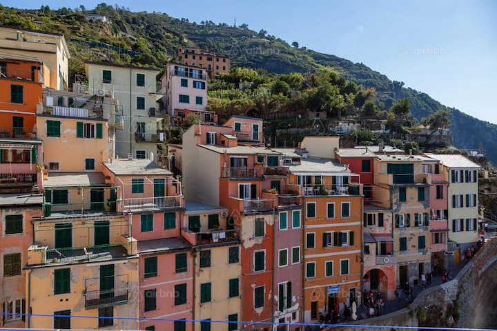 Colorful hillside village of stacked homes illustrating tourism’s impact on small coastal communities.