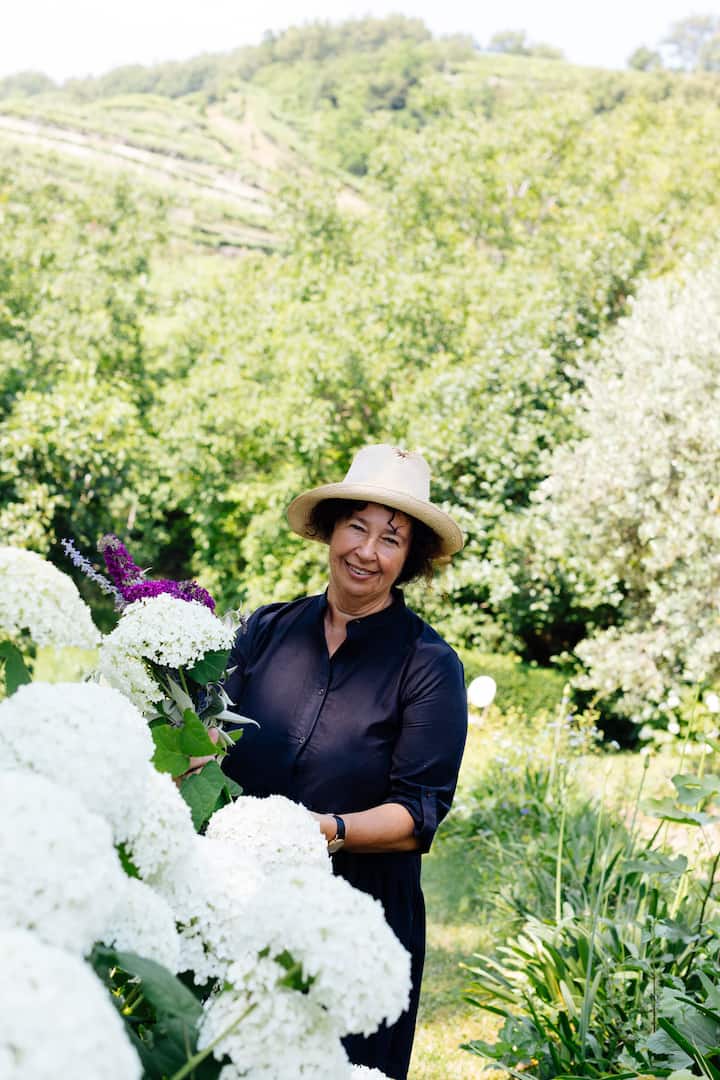 Host Mara cura ortensie bianche nel giardino della sua dimora tra le colline verdi della Valpolicella.