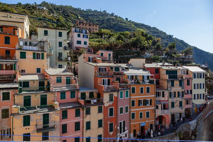 Colorful hillside apartments in a coastal town, illustrating dispersed tourism beyond major city centers.