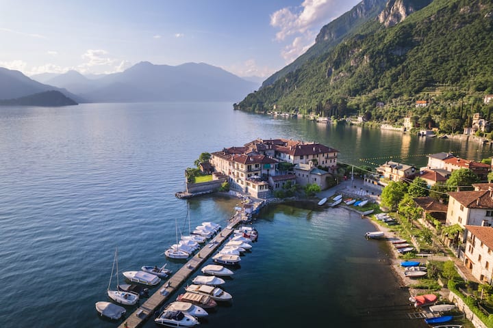 Borgo sul lago italiano con piccola marina, esempio di turismo nei piccoli comuni raggiungibili con Airbnb