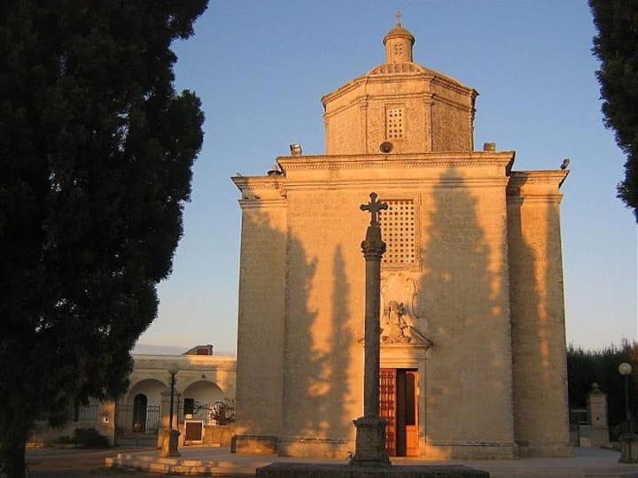Piccola chiesa di pietra in un borgo italiano al tramonto, simbolo dei comuni rurali su Airbnb