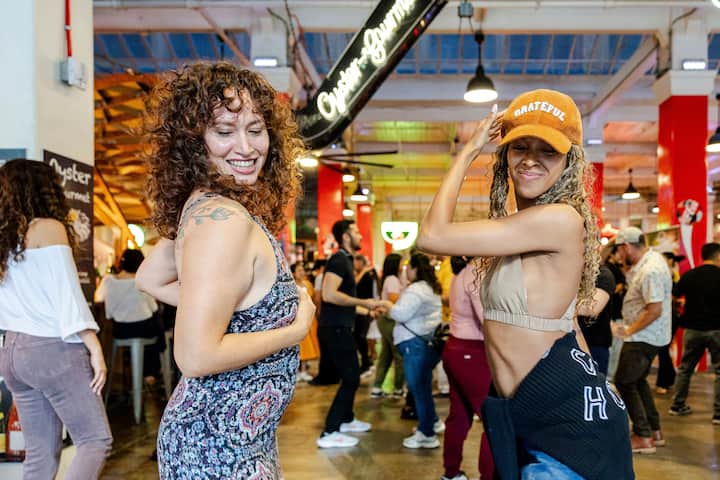 People dancing together at Grand Central Market in Downtown Los Angeles during an Airbnb Experience.