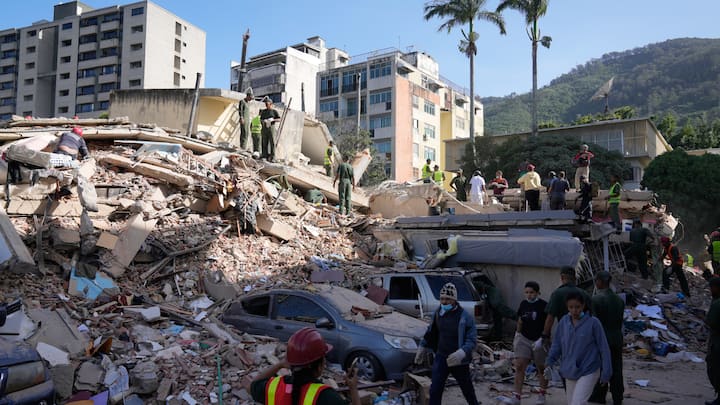 Soccorritori e residenti perlustrano edifici crollati e auto schiacciate dopo un terremoto in un quartiere di una città venezuelana.