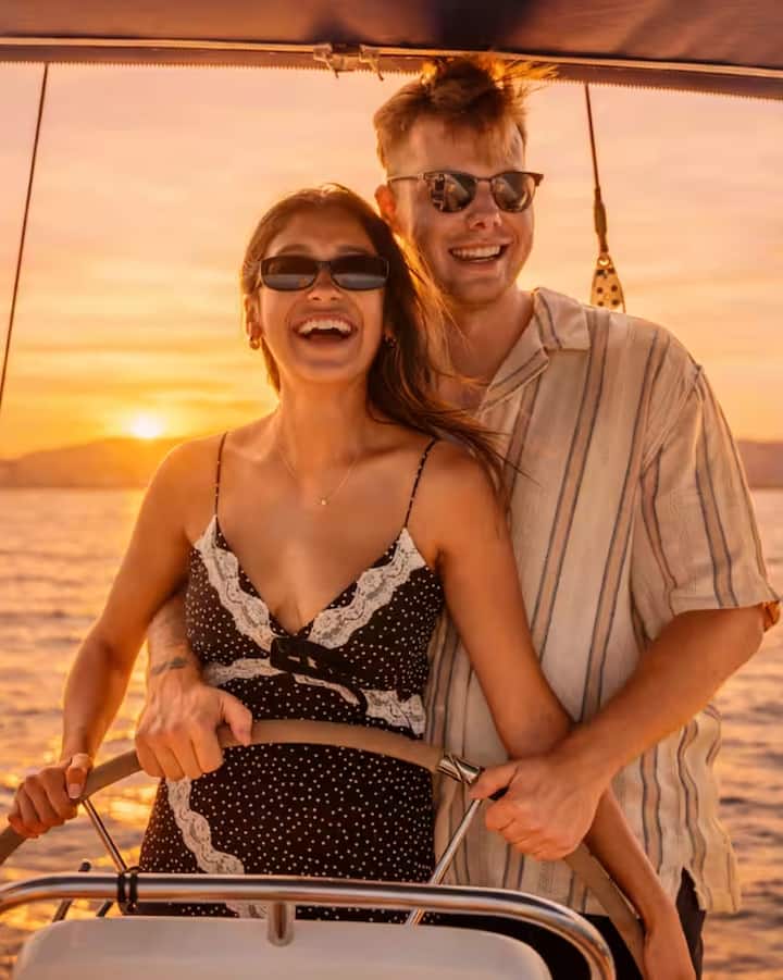 Una pareja sonriente navega a la hora mágica en Barcelona mientras disfruta de una excursión dedicada al eclipse.