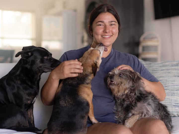 Woman and her three dogs sitting on the couch in their Airbnb.org stay.