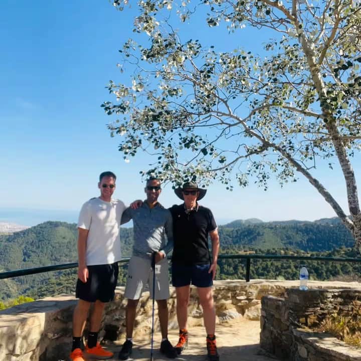 Un grupo de amigos posa en un mirador de piedra en la franja de observación del eclipse de España, con amplias vistas de las montañas y el cielo a sus espaldas.