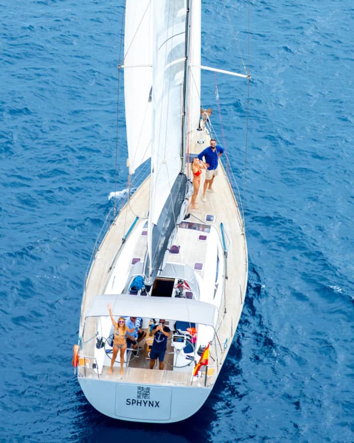 Unos viajeros en un velero frente a Barcelona miran al cielo y disfrutan de una experiencia dedicada al eclipse.
