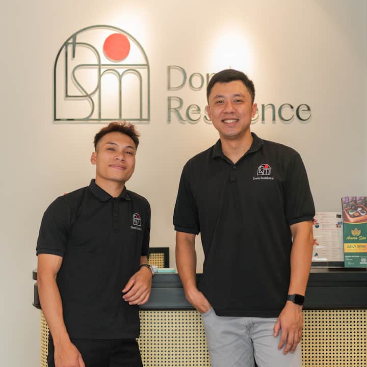 Khoi and Dong smiling behind the Dong Residence front desk in Hanoi, Vietnam