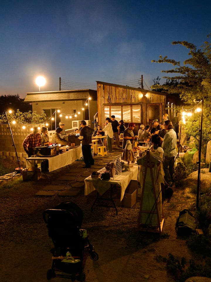 Evening outdoor gathering at a Goseong Airbnb, with guests dining under warm string lights
