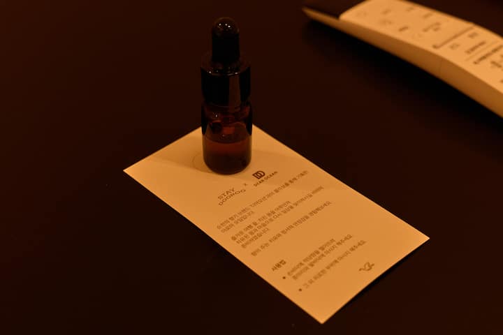 Amber dropper bottle of skincare serum displayed on a card with Korean text in a Suncheon Airbnb stay.