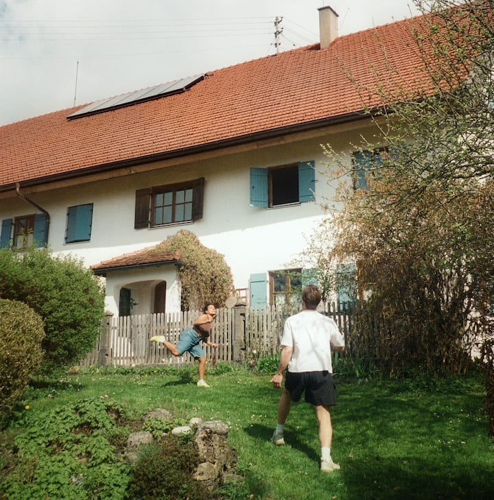 Guests enjoying a game in a tidy green garden outside a cozy house, evoking confidence in well-reviewed, spotless Airbnb stays.