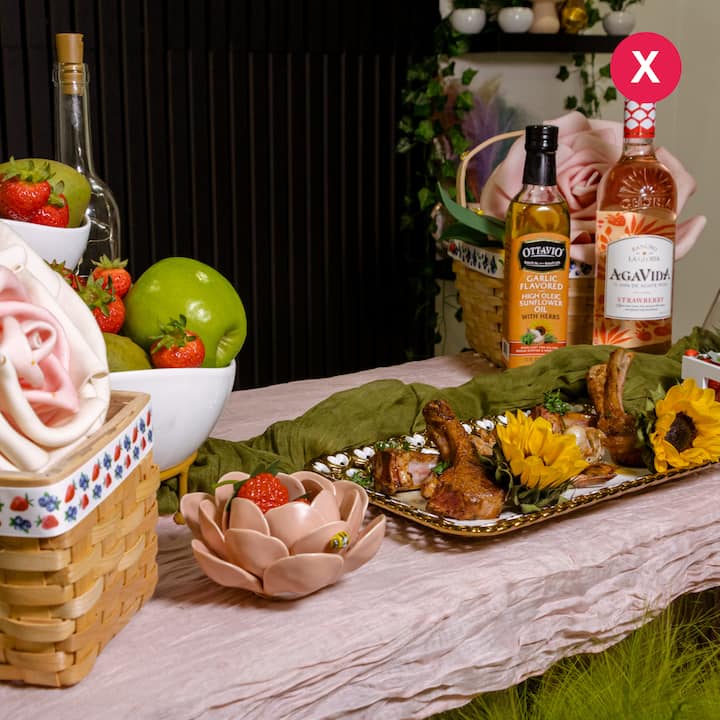 Elaborate but cluttered table display of food, props, and bottles, illustrating an example of what not to do in professional listing photos.