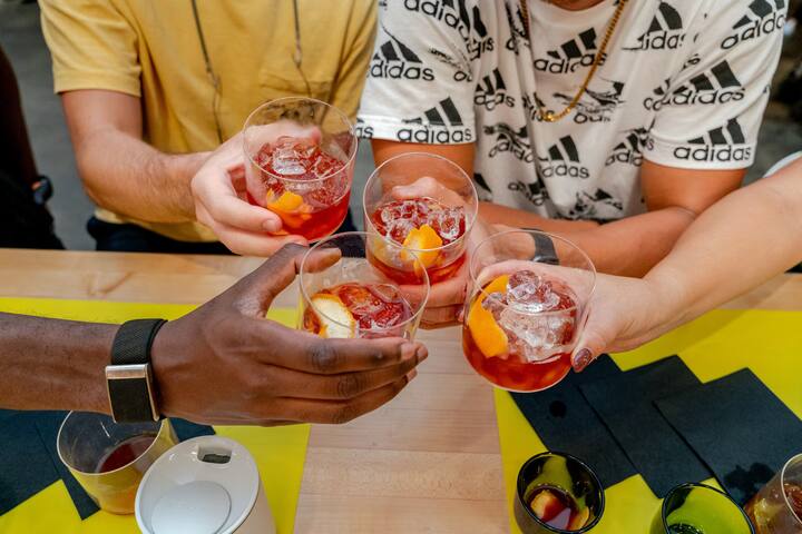 Friends toasting colorful cocktails during an Airbnb experience at Grand Central Market, Downtown Los Angeles