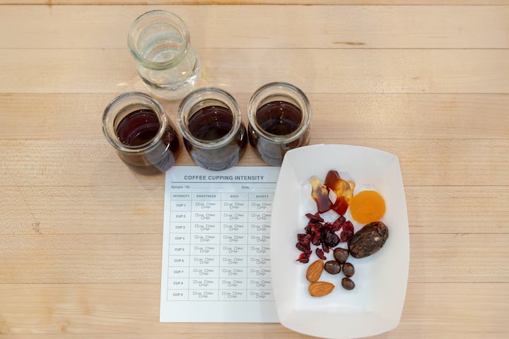 Coffee cupping setup at Grand Central Market with tasting jars, score sheet, and nuts and dried fruit