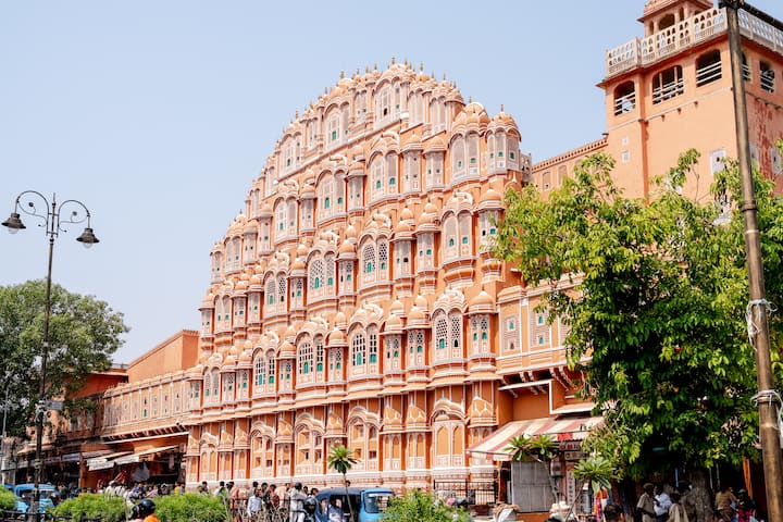 Historic Hawa Mahal in Jaipur rising over shops and rickshaws, showcasing India’s colorful spirit