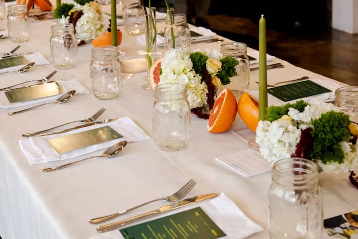 Elegant New York City dining table set with citrus, flowers, menus, and candles for the Parmigiano Reggiano Collection.