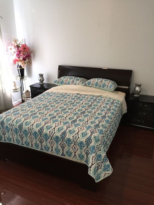 Comfy queen size bed in bedroom.