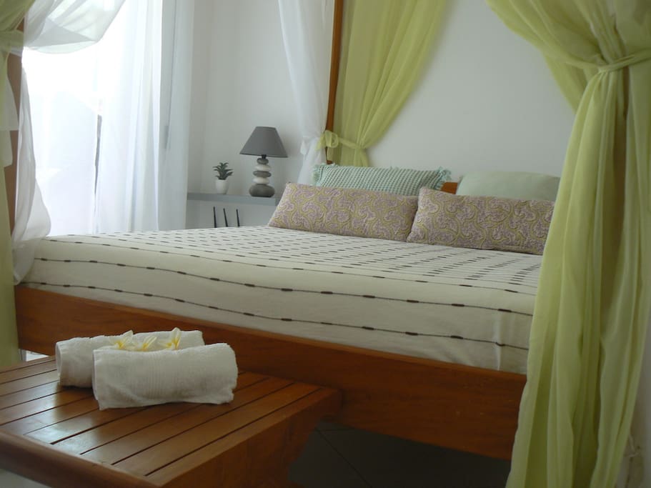 Chambre donnant sur la terrasse -lit baldaquin .