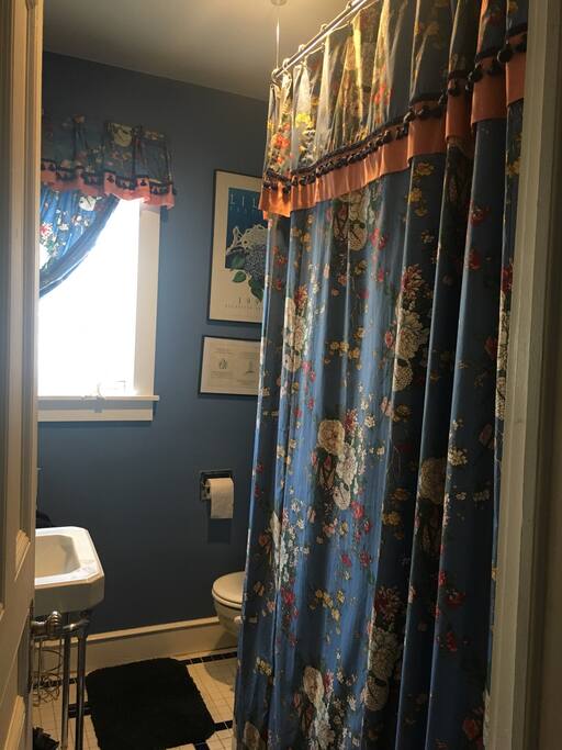 A glimpse into the shared bathroom, with shower and deep bathtub.