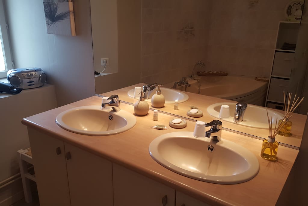 Double vasque avec sèche cheveux et serviettes de toilette.