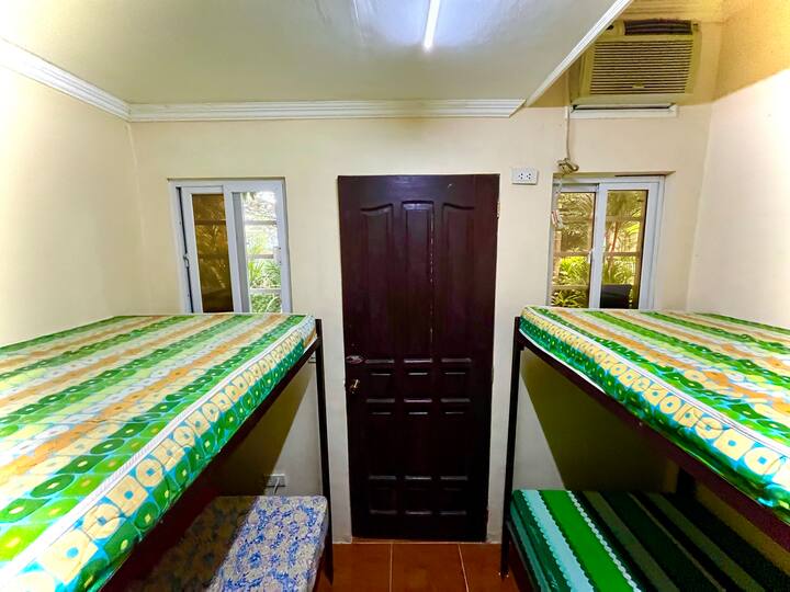 DHOMË KOPSHTI me 4 krevate në 2 krevate. Dhomë me ajër të kondicionuar. Hyrje ekskluzive përmes kopshtit anësor.