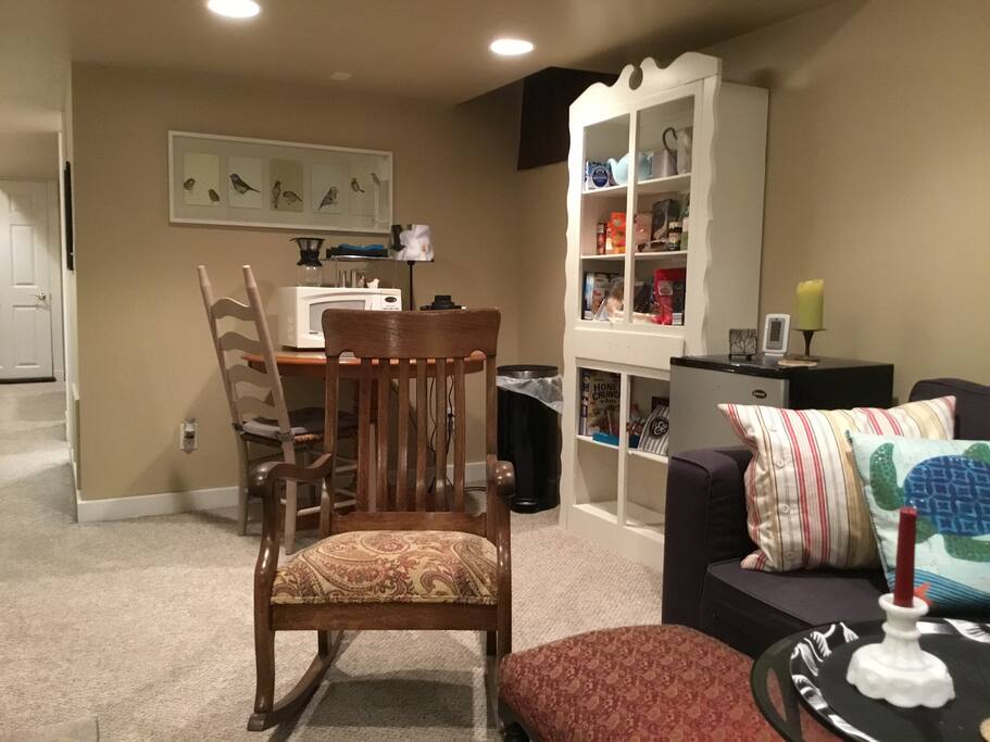 Kitchen area includes microwave, small refrigerator, coffee maker, food storage