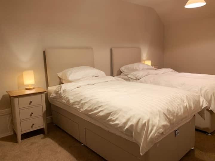 Slaapkamer-2 is een ruime kamer met twee enkele divanbedden, puur katoenen beddengoed, alle seizoenen Hongaarse veren & dons dekbedden en een combinatie van veren en dons en holle vezel kussens. Een volledige hangende kledingkast en ladekast bieden voldoende ruimte voor kleding.