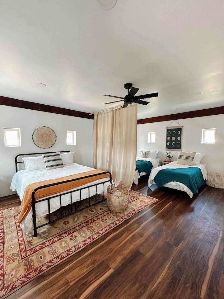 A curtain divider between a queen bed and 2 single beds