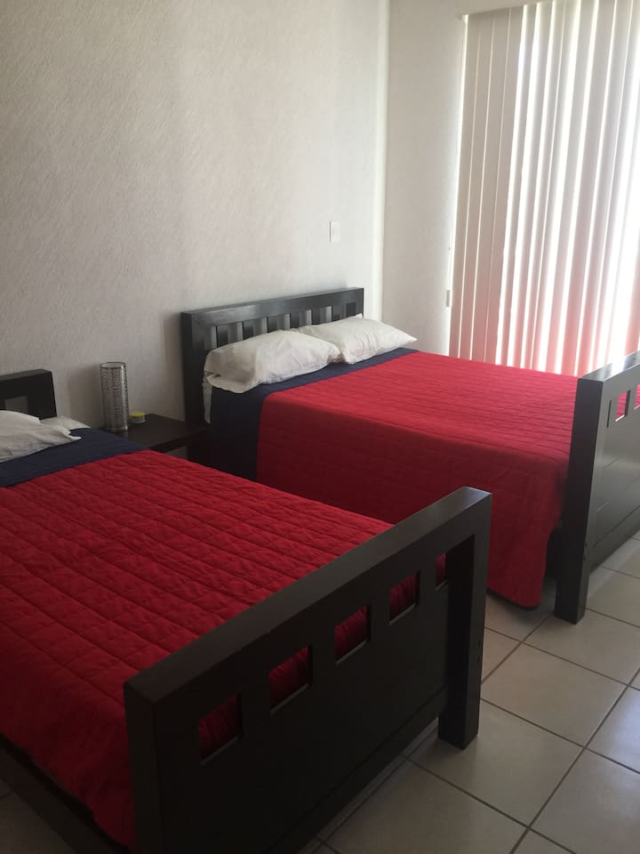 חדר שינה ראשי עם טלוויזיה, מיזוג אוויר וחדר רחצה ושירותים 