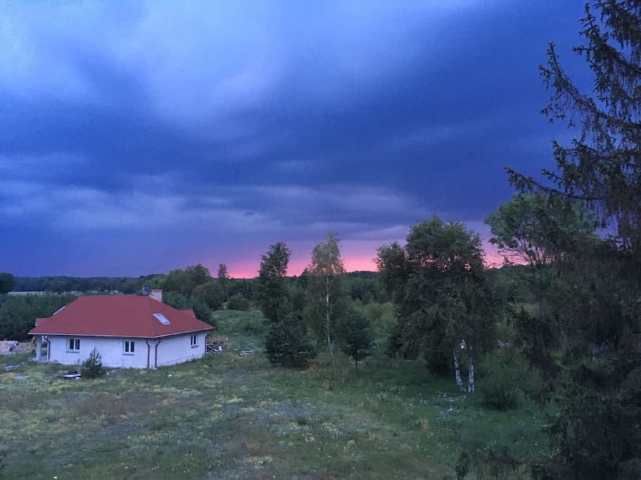 The view from the rooftop of the main house towards the small house, where the landlord lives, just before the summer storm.
