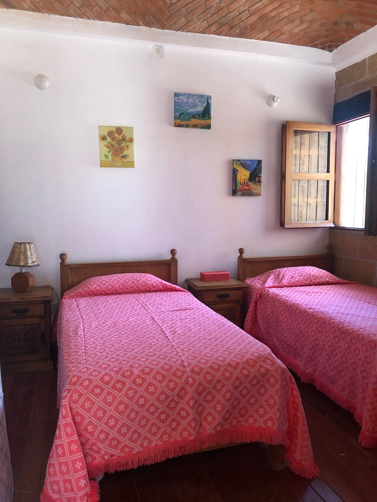 Spavaća soba s dva kreveta za jednu osobu koji se spajaju s kupaonicom.