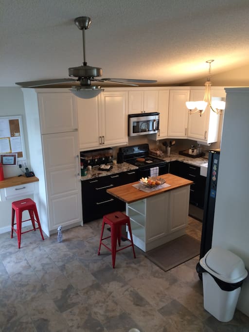 Beautifully renovated kitchen with granite counter tops, eat at island, 4 appliances, ceramic tile and gorgeous farm house sink