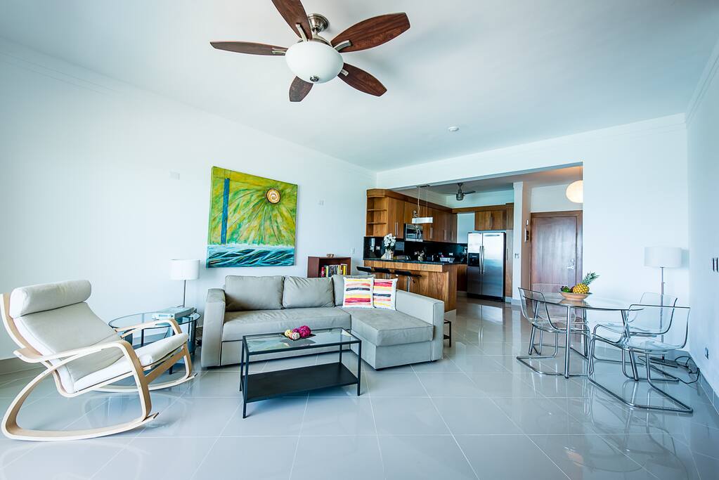 A spacious living/dining room with paintings by local artist Leo Diaz
