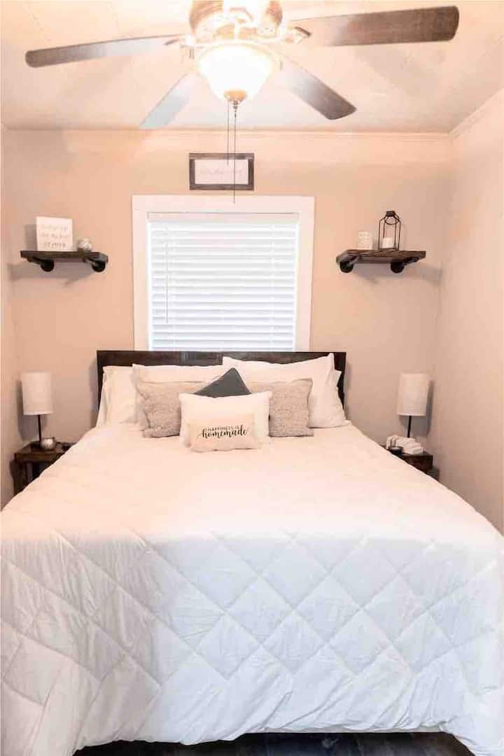 Enjoy our Cozy Queen Handmade Farmhouse bed equipped with multiple pillows and 32 inch TV.