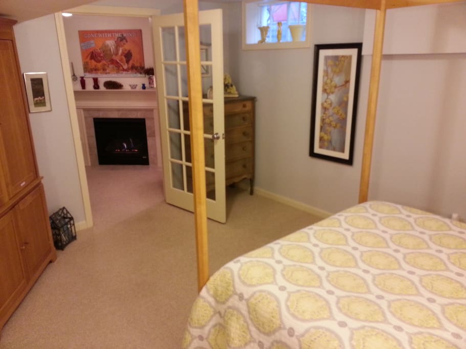 A dresser and wardrobe for storing your clothes and a view of the fireplace from bed.
