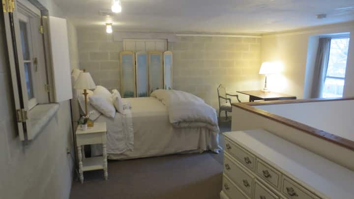 dormitorio loft con cama tamaño Queen