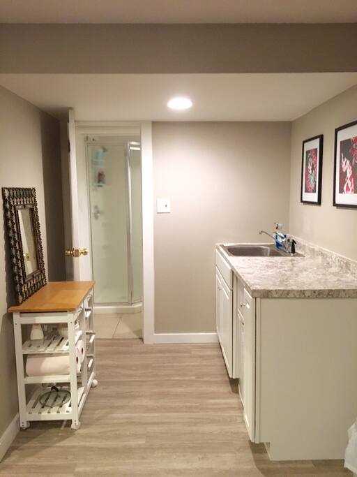 Kitchen area leading into the bathroom, with a new standup shower in it .