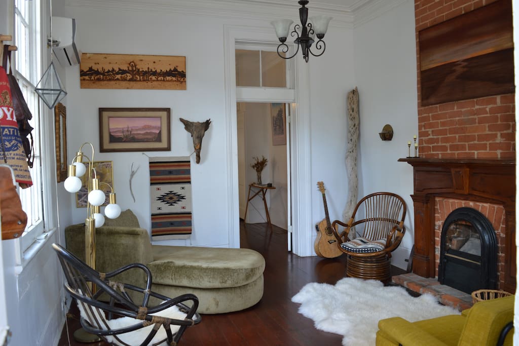 Sun drenched front room with high ceilings, filled with charm and worldly characteristics.