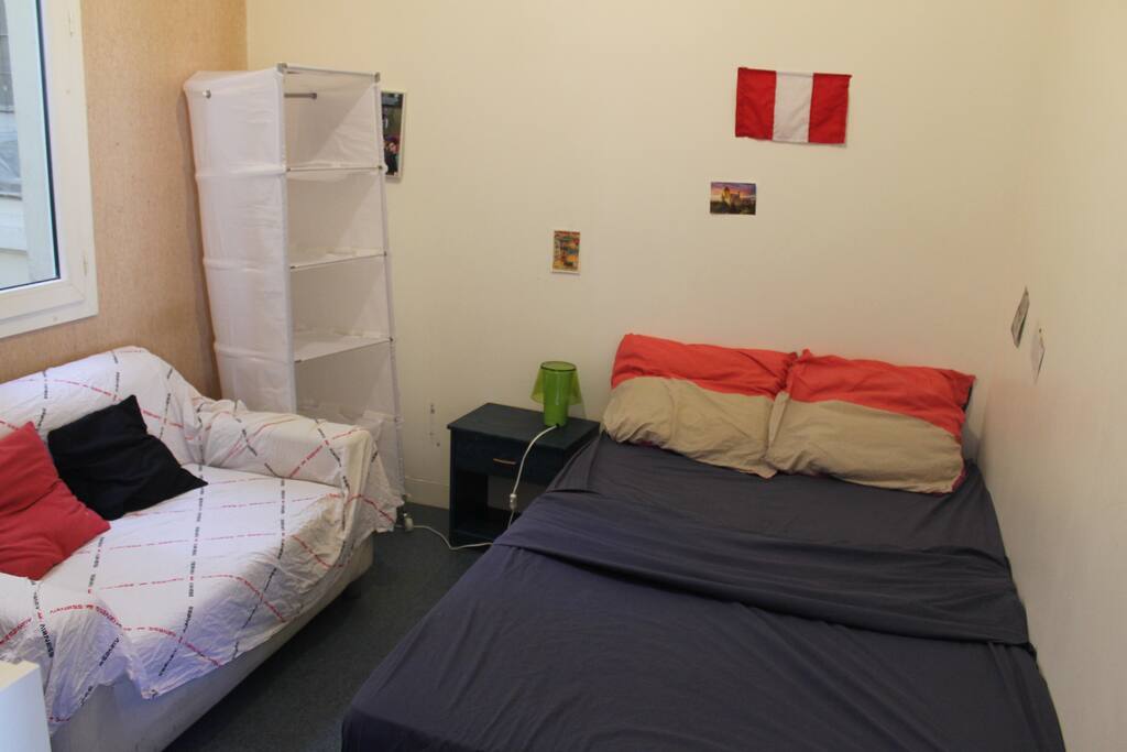 La chambre : lit double, un canapé, une lampe de chevet une des deux armoires en toile