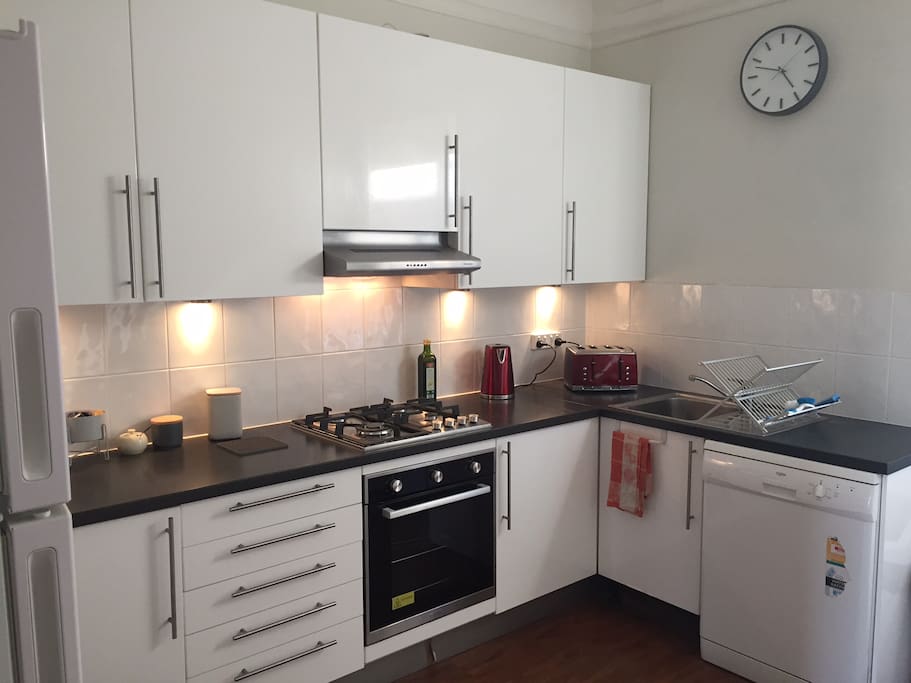 Kitchen contains new appliances, coffee pod machine with pods, dishwasher and washing machine.